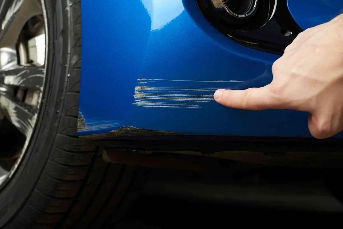 Close-up of a deep scratch along a car door being colour-matched